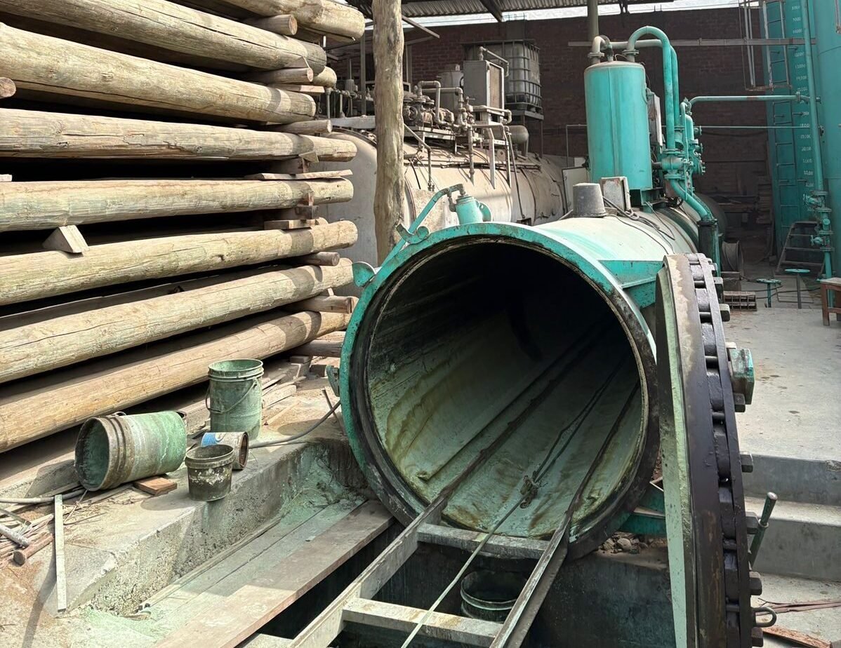 Carguío pesado de postes de madera en planta